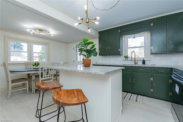 kitchen featuring a breakfast bar area, a center island, backsplash, and green cabinets