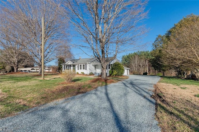 view of front of property with a garage, a front yard, and gravel driveway