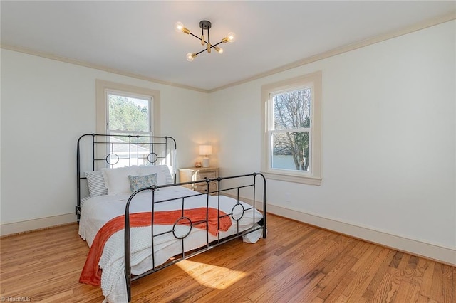 bedroom with baseboards, a notable chandelier, ornamental molding, and wood finished floors