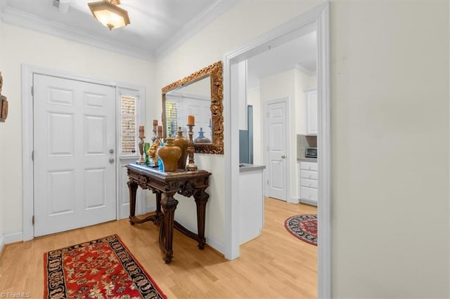 foyer with ornamental molding and light hardwood / wood-style floors