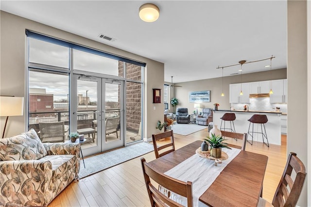 dining space featuring visible vents, french doors, and light wood-style flooring