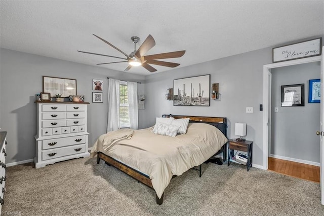 carpeted bedroom featuring a ceiling fan, baseboards, and a textured ceiling