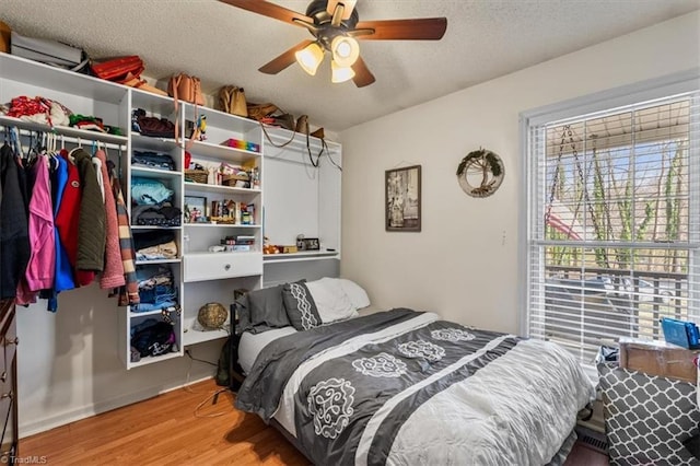 bedroom featuring ceiling fan, a textured ceiling, and wood finished floors