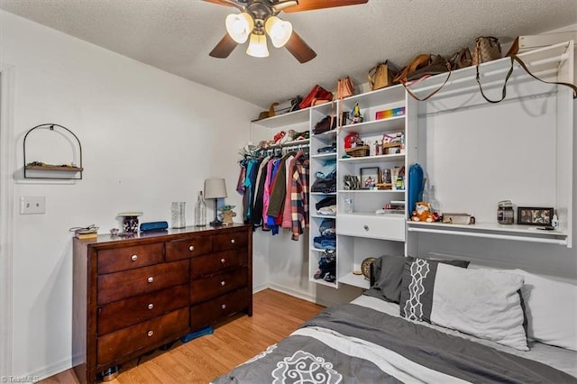 bedroom with a textured ceiling, wood finished floors, and a ceiling fan