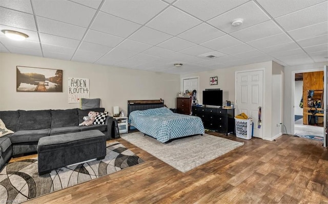 bedroom featuring a paneled ceiling and wood finished floors