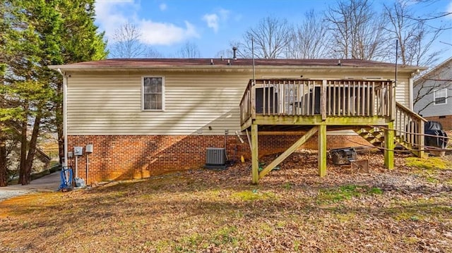 back of property with central AC, brick siding, a wooden deck, and stairs