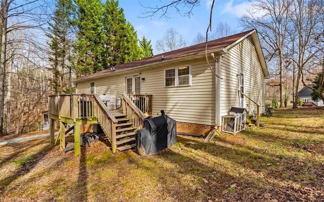 rear view of house featuring a lawn and a deck