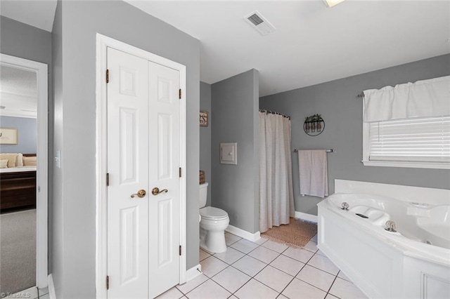 bathroom with tile patterned flooring, toilet, and a washtub