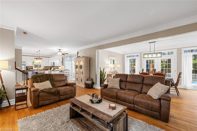 living room with ceiling fan, light hardwood / wood-style floors, and ornamental molding