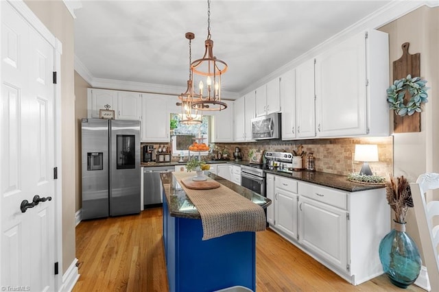 kitchen with white cabinetry, a kitchen island, stainless steel appliances, and light wood-type flooring