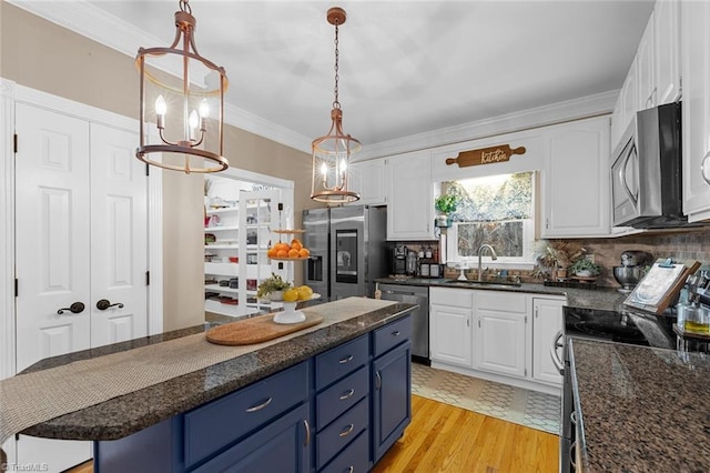 kitchen with white cabinets, stainless steel appliances, tasteful backsplash, and blue cabinetry