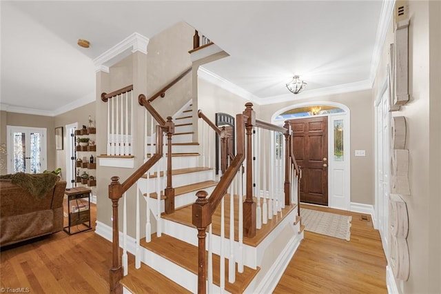 entryway with light wood-type flooring, ornamental molding, french doors, and a chandelier