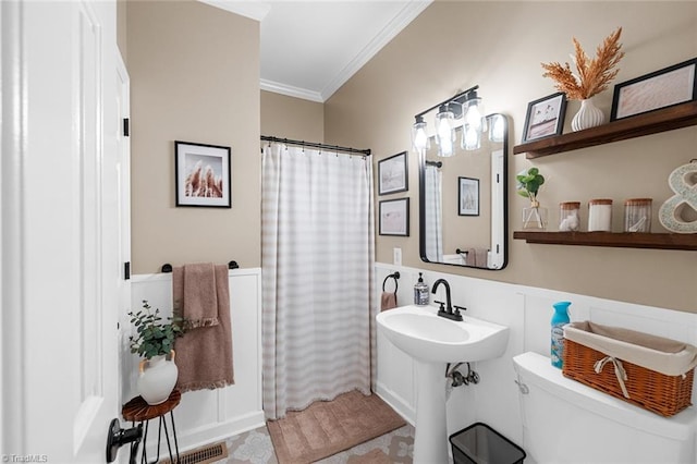 bathroom with a shower with curtain, toilet, and crown molding