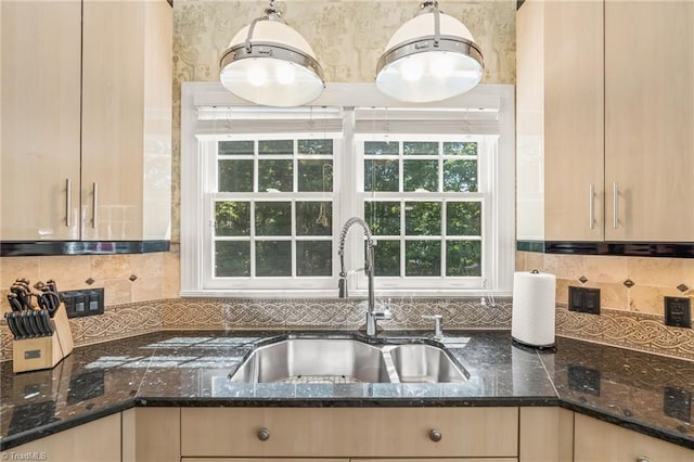 kitchen featuring decorative backsplash, decorative light fixtures, dark stone counters, and sink