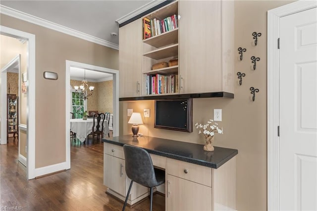 office space featuring built in desk, an inviting chandelier, dark wood-type flooring, and ornamental molding