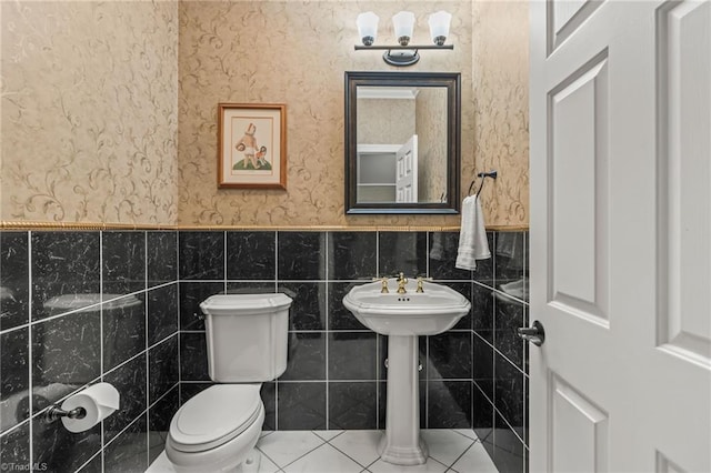 bathroom with tile patterned floors, toilet, and tile walls