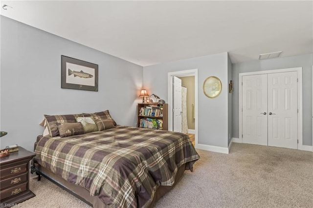 bedroom with carpet flooring, ensuite bath, and a closet