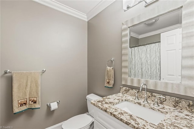 bathroom featuring toilet, vanity, and ornamental molding