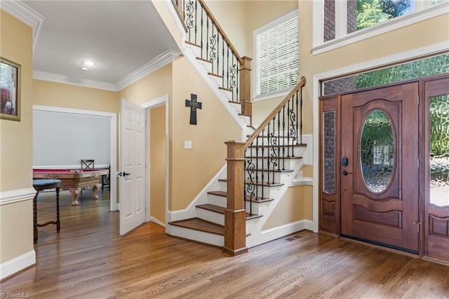 entryway featuring wood-type flooring, ornamental molding, and billiards