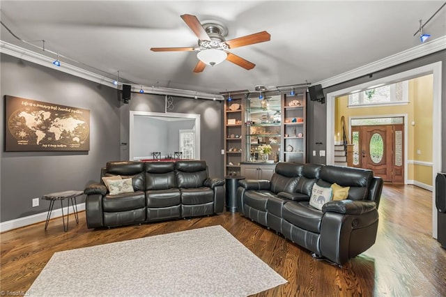 cinema featuring built in shelves, dark hardwood / wood-style floors, ceiling fan, and crown molding