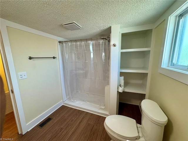 full bathroom featuring visible vents, wood finished floors, curtained shower, and toilet