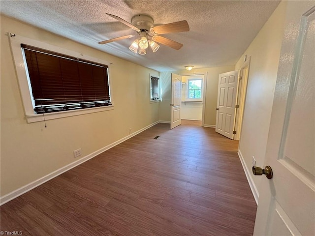 empty room with ceiling fan, baseboards, wood finished floors, and a textured ceiling