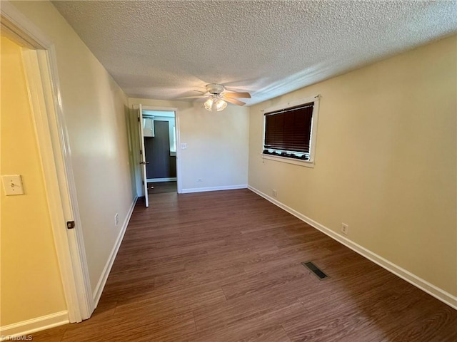 unfurnished room featuring wood finished floors, visible vents, baseboards, a textured ceiling, and ceiling fan