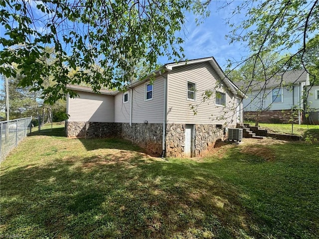 view of property exterior featuring a fenced backyard, a yard, and central air condition unit