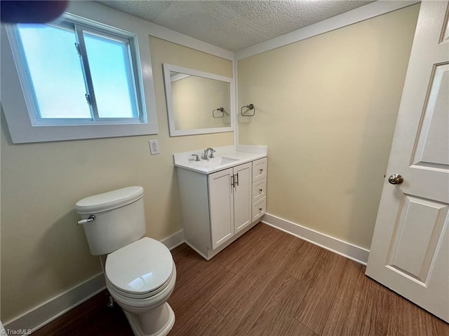 half bath featuring wood finished floors, a textured ceiling, toilet, and baseboards