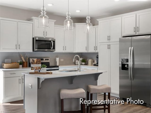 kitchen featuring white cabinetry, tasteful backsplash, appliances with stainless steel finishes, and a sink