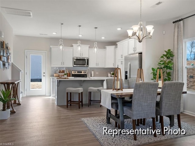 dining space featuring a notable chandelier, visible vents, recessed lighting, and dark wood-type flooring