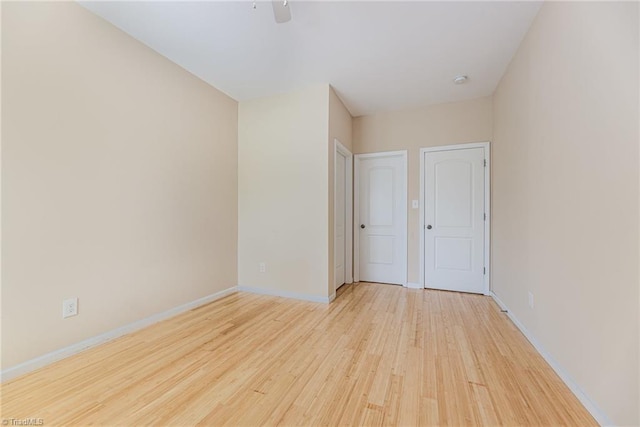empty room with baseboards, a ceiling fan, and wood finished floors