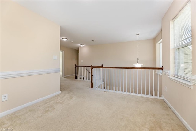 empty room featuring carpet and baseboards