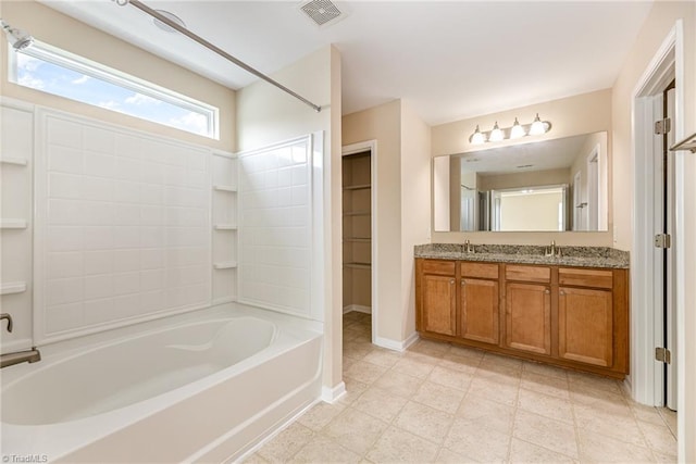 bathroom featuring double vanity, visible vents, baseboards, and a sink