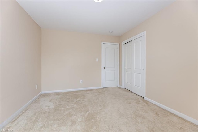 spare room with light carpet and baseboards