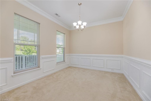 empty room featuring a chandelier, visible vents, ornamental molding, and wainscoting
