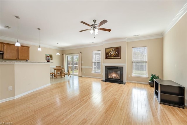 living room with visible vents, a ceiling fan, a fireplace with flush hearth, and light wood finished floors