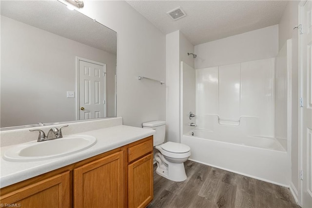 5207 Highland Oak Ct, Greensboro, NC 27410 - bathroom with vanity, wood finished floors, a textured ceiling, and  shower combination