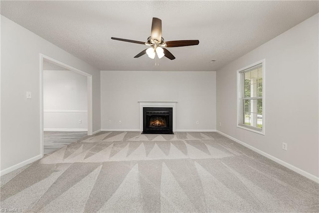 5207 Highland Oak Ct, Greensboro, NC 27410 - unfurnished living room with a textured ceiling, carpet floors, a fireplace with flush hearth, and a ceiling fan