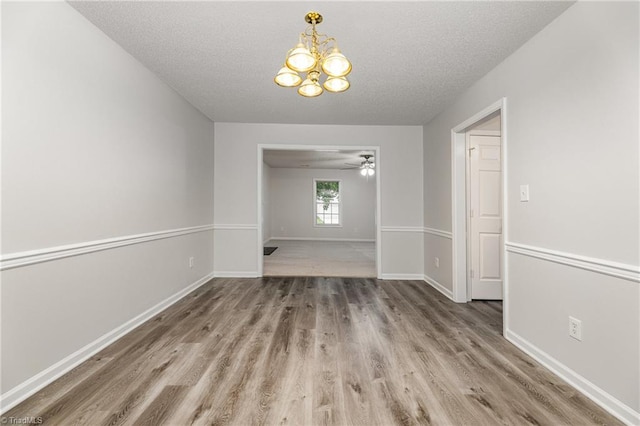 5207 Highland Oak Ct, Greensboro, NC 27410 - unfurnished dining area featuring a chandelier, wood finished floors, a textured ceiling, and ceiling fan
