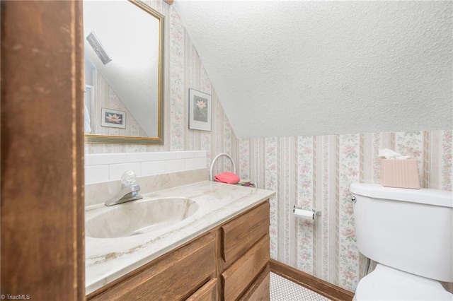 1920 Chateau Rdg, Winston-Salem, NC 27103 - bathroom featuring wallpapered walls, vanity, toilet, a textured ceiling, and vaulted ceiling