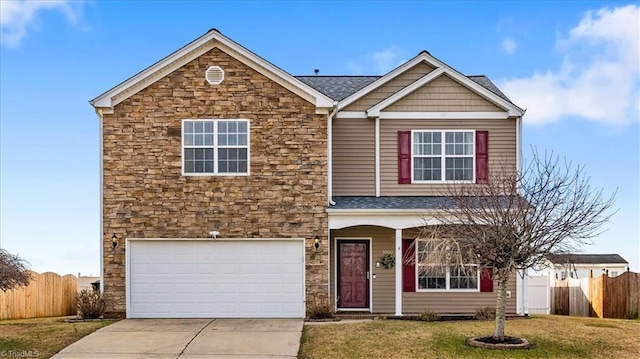 view of front of property featuring concrete driveway, a front lawn, stone siding, and fence