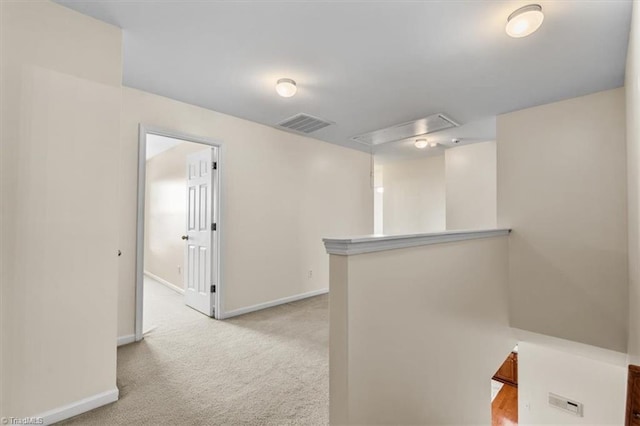 hall with baseboards, visible vents, light colored carpet, and an upstairs landing