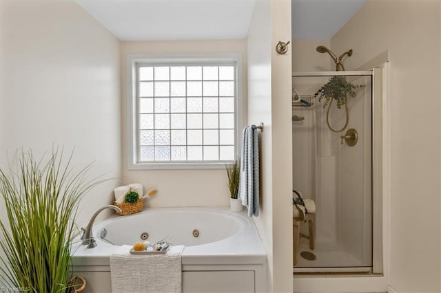 bathroom with a stall shower and a tub with jets