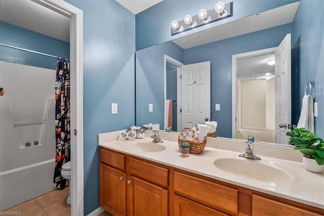 full bathroom with double vanity, a sink, toilet, and tile patterned floors