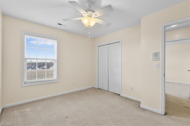 unfurnished bedroom with ceiling fan, carpet floors, visible vents, baseboards, and a closet