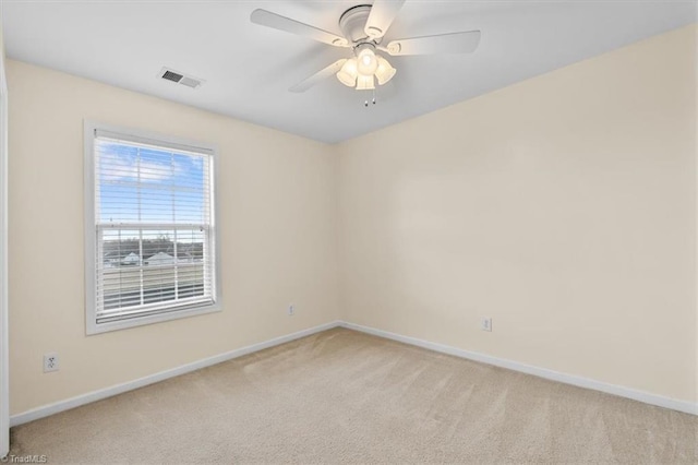 empty room featuring light carpet, baseboards, visible vents, and a ceiling fan