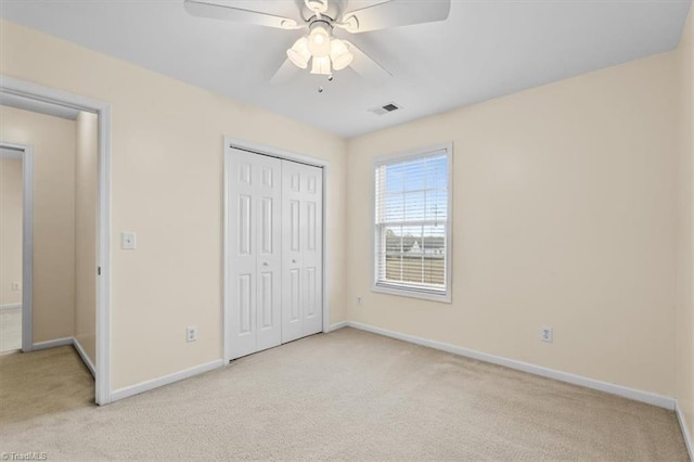 unfurnished bedroom featuring a closet, carpet flooring, visible vents, and baseboards