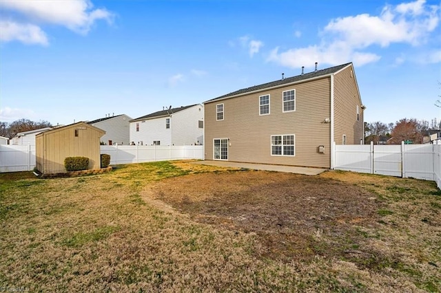 back of property with a fenced backyard, a lawn, and an outdoor structure