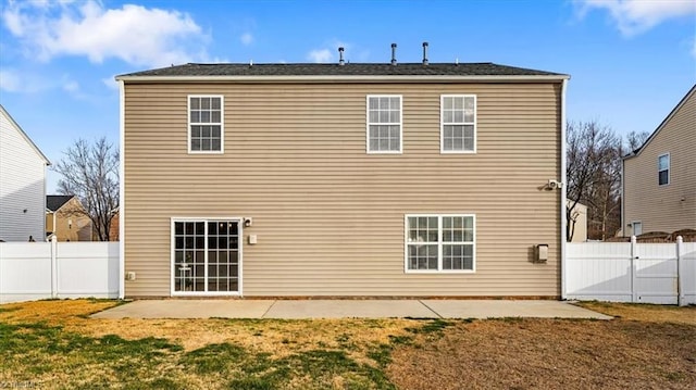 rear view of house with a patio, a lawn, and a fenced backyard